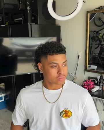 Drop fade with a curly top, client in a white tee in the home studio